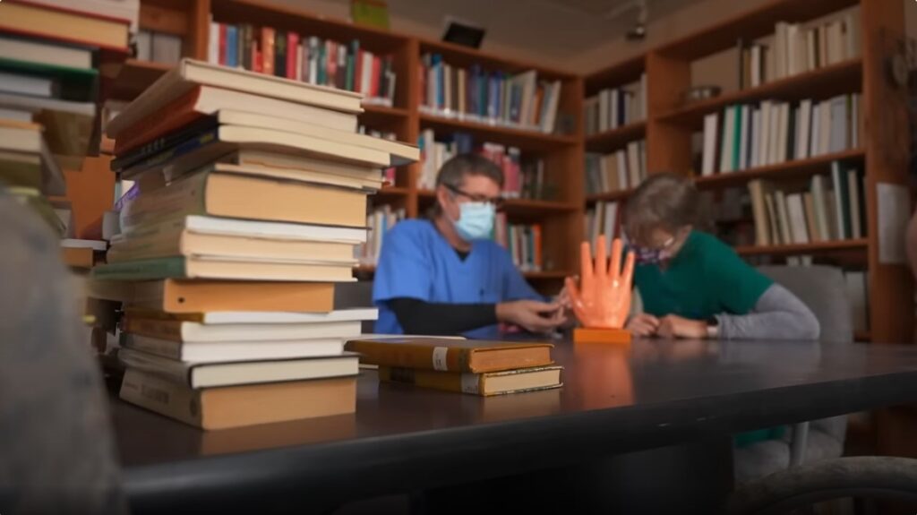 learn acupuncture nathan anderson and student with books